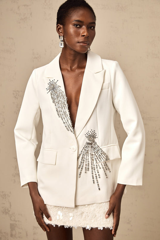A white blazer adorned with crystal embellishments featuring a tailored fit and elegant design