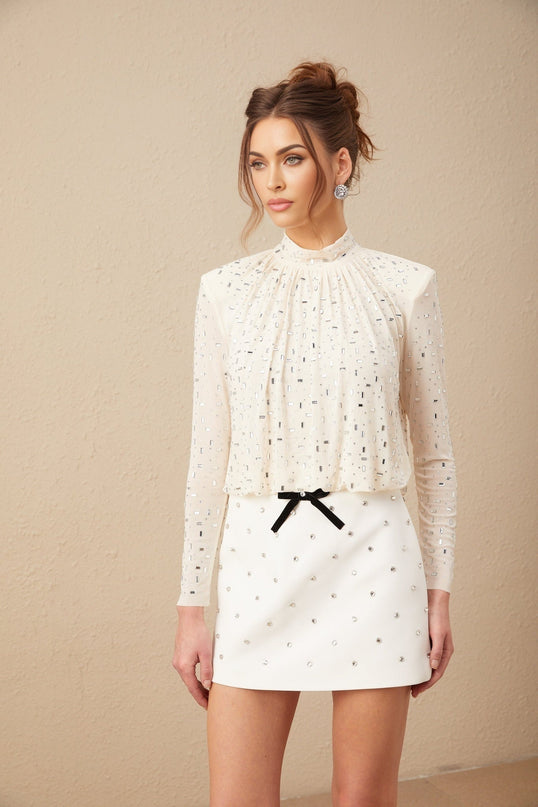 A white blouse with crystal embellishments featuring a romantic Valentineinspired design