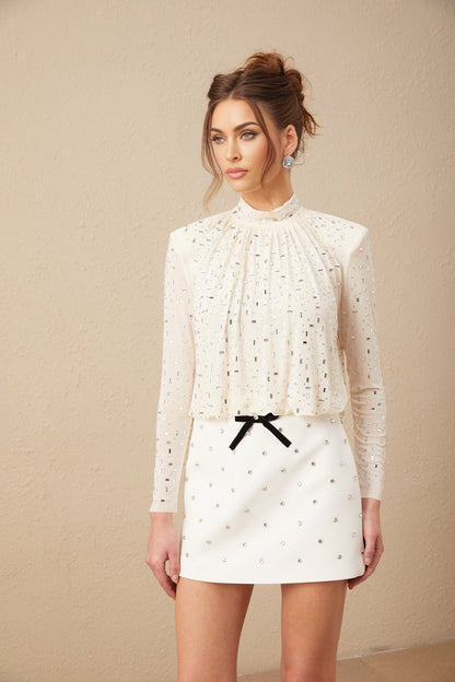 A white blouse with crystal embellishments featuring a romantic Valentineinspired design