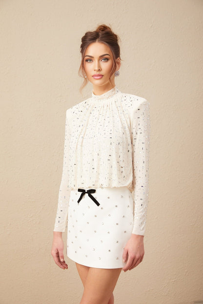 A white blouse with crystal embellishments suitable for Valentines Day featuring a feminine design and sparkly accents