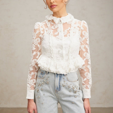 A white blouse with delicate floral embroidery and lace detailing named Karine