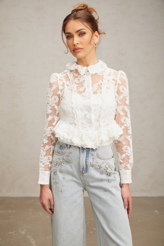 A white blouse with delicate floral embroidery and lace detailing named Karine