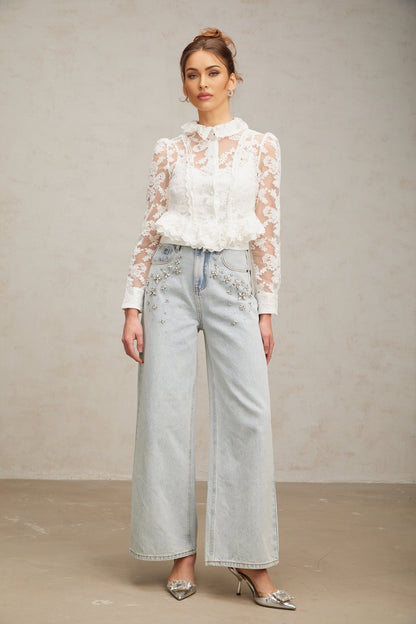 A white blouse with delicate floral embroidery and lace detailing named Karine