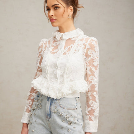 A white blouse with delicate floral embroidery and lace detailing named Karine