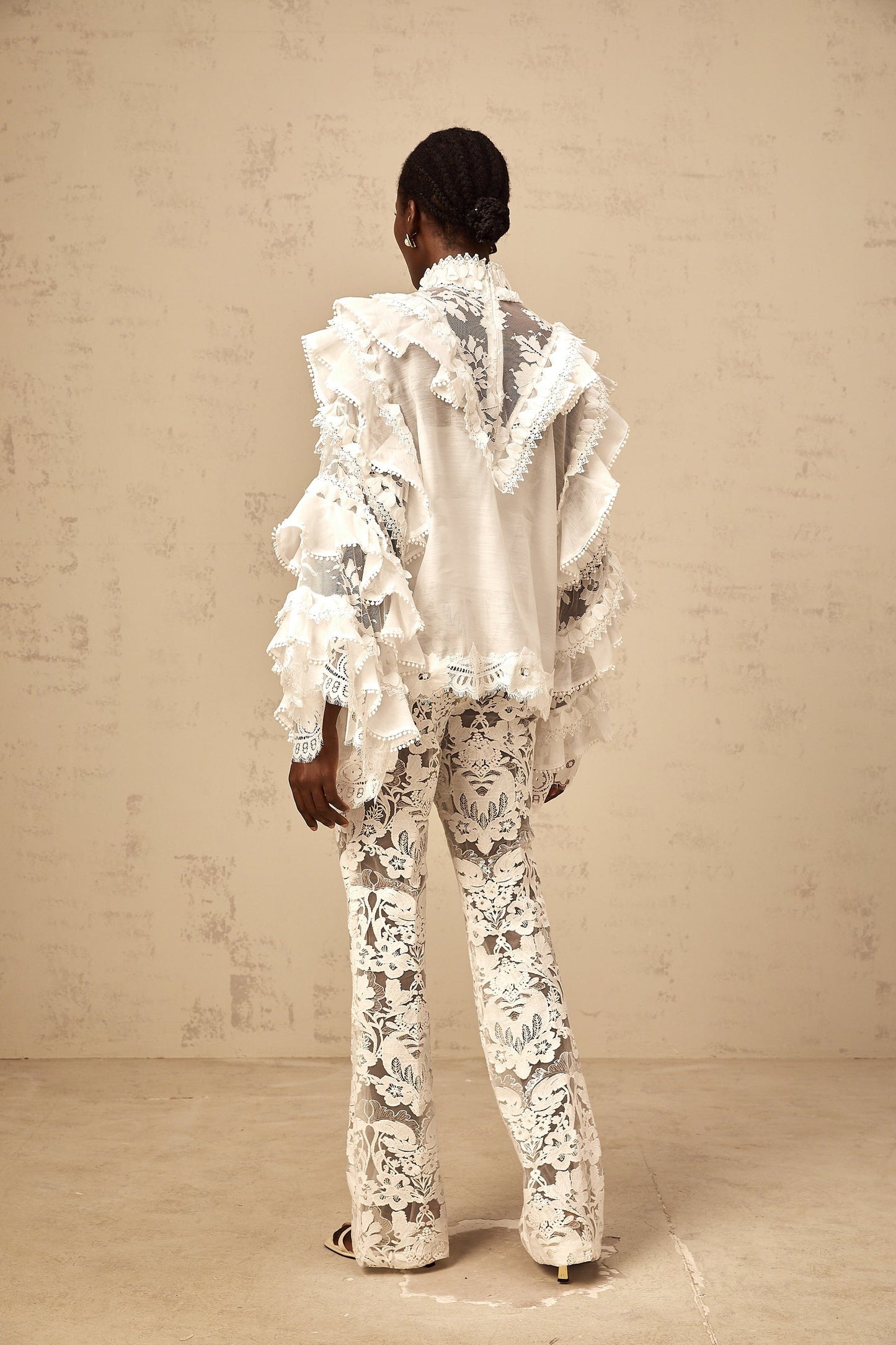 A white blouse with layered lace details and a tied front featuring a delicate design by Mylene