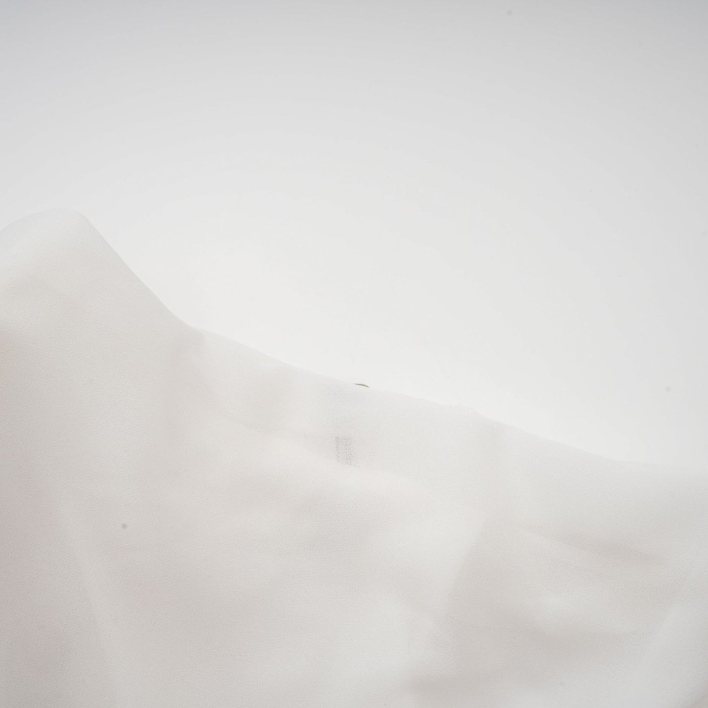 A white chiffon blouse with a flowy design named Jeanne