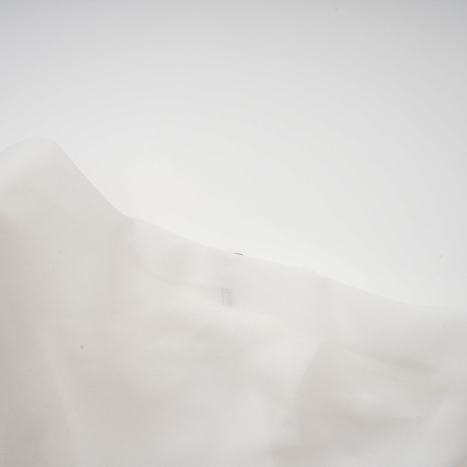 A white chiffon blouse with a flowy design named Jeanne