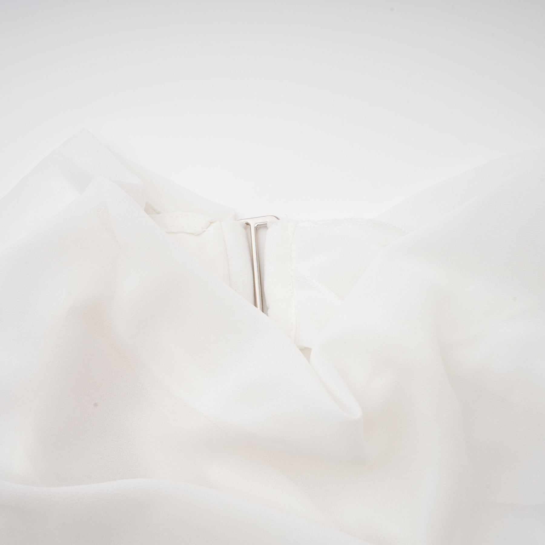 A white chiffon blouse with a loose and flowing design named Jeanne