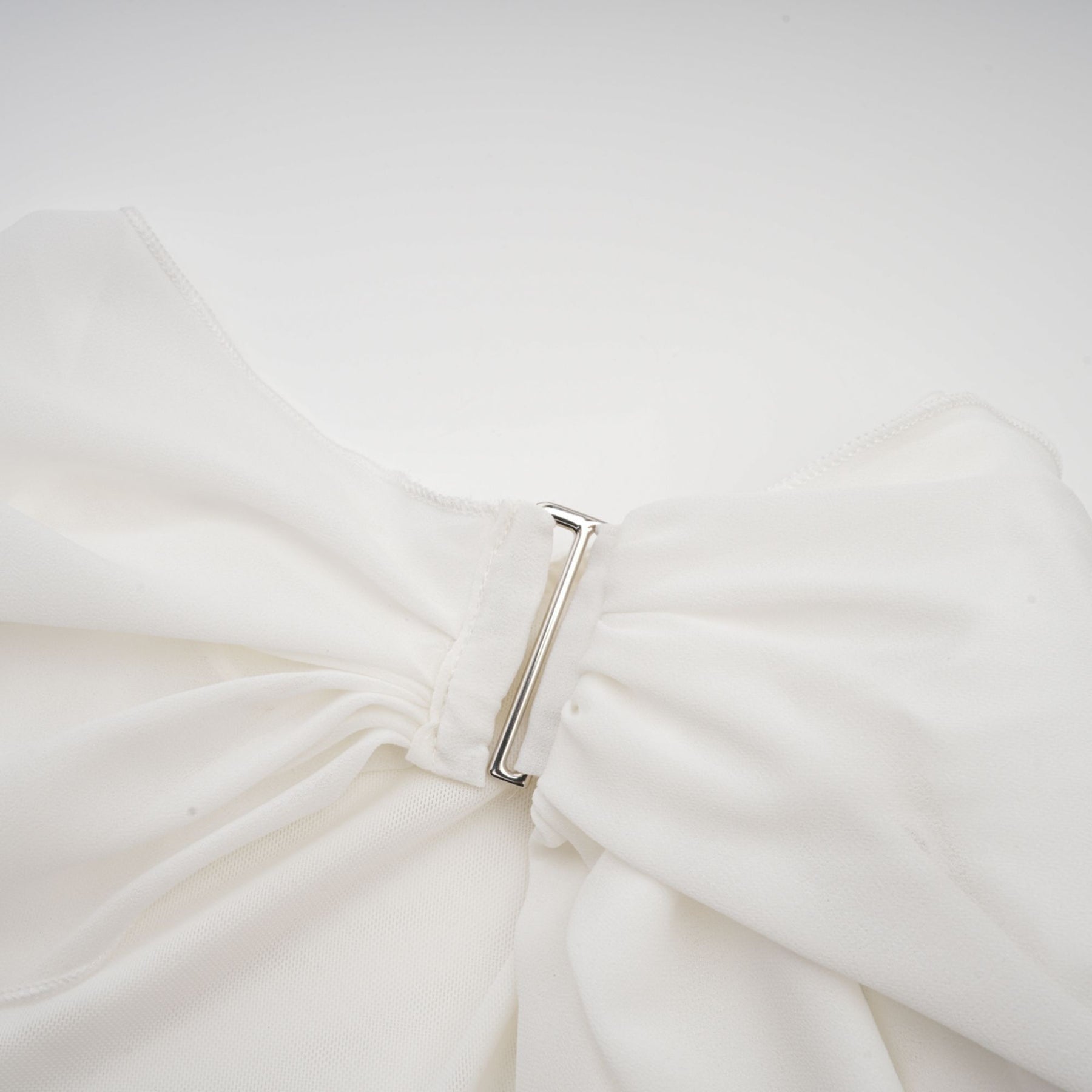 A white chiffon blouse with a loose fit and flowy sleeves named Jeanne