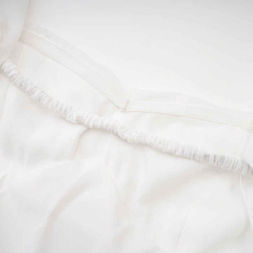 A white chiffon maxi dress with a halter neck and ruffle details named Mariah