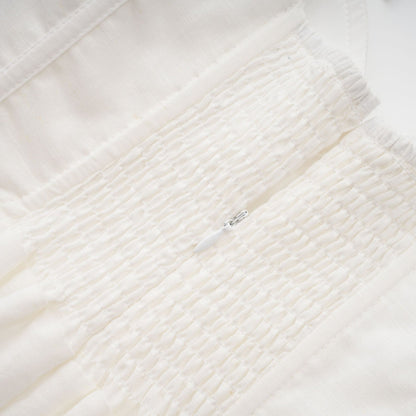 A white corset style midi dress with a fitted bodice and flared skirt worn by a model standing against a plain background