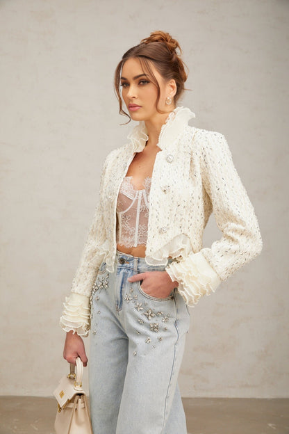 A white cropped jacket with beaded embellishments and ruffle details along the edges named Blanche