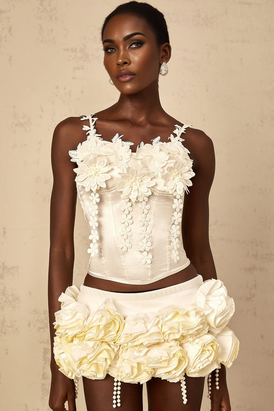 A white cropped top with delicate floral embroidery details and short sleeves