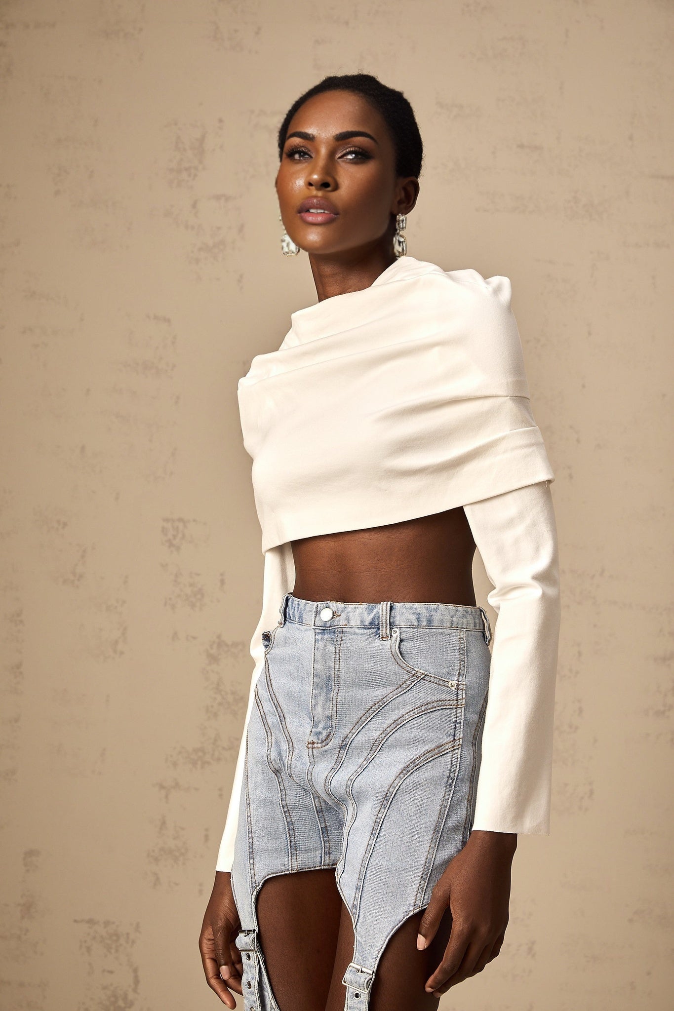 A white cropped top with ruched detailing named Hanna worn by a model against a plain background