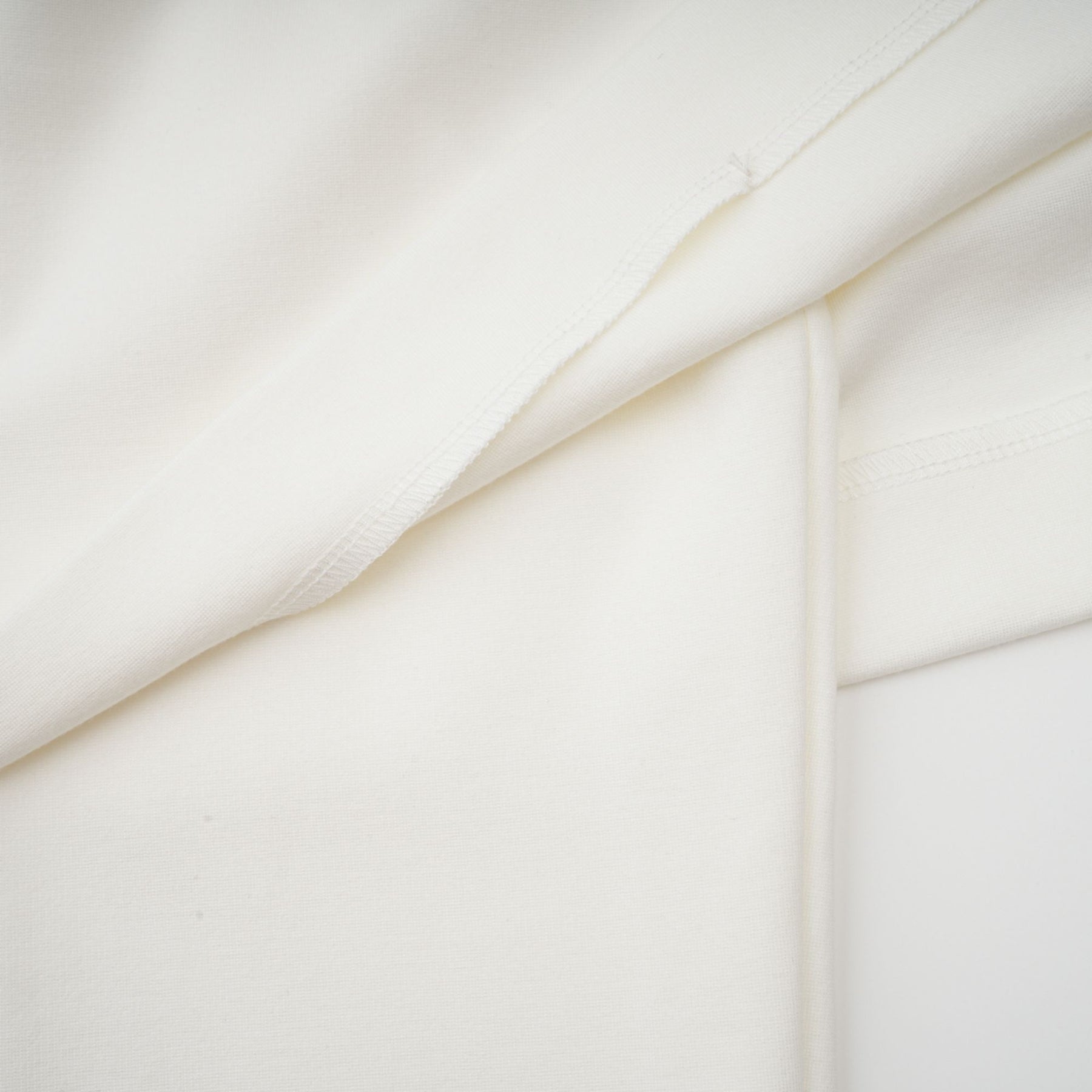 A white cropped top with ruched detailing named Hanna worn by a model against a plain background