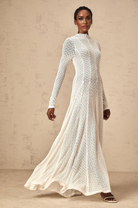 A white floorlength maxi dress with an allover wavy lace pattern featuring a fitted bodice and flowing skirt