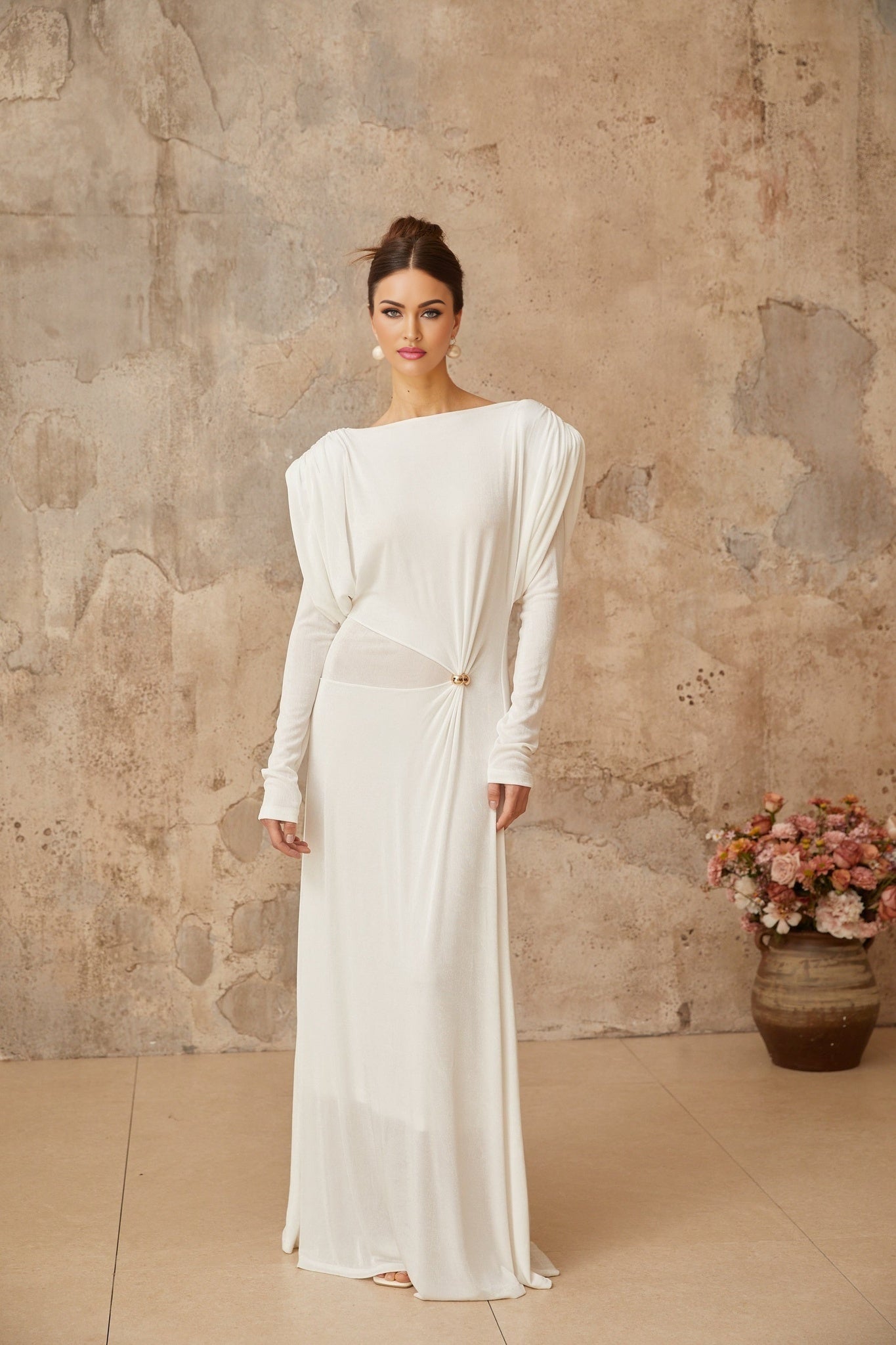 A white floorlength maxi dress with draped fabric and shirred detailing named Margot