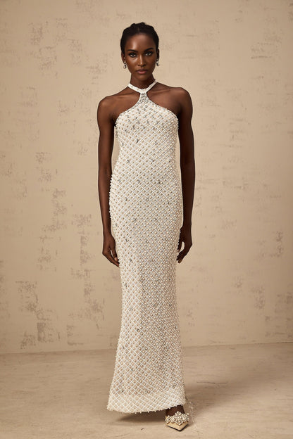A white halterneck maxi dress with embellishments named Claudine featuring a long flowing skirt and sleeveless design