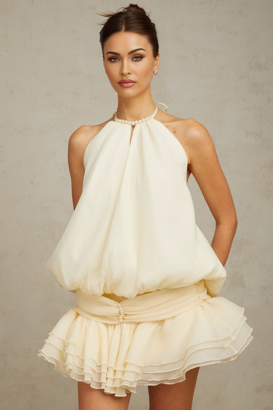 A white halterneck mini dress with faux pearl embellishments