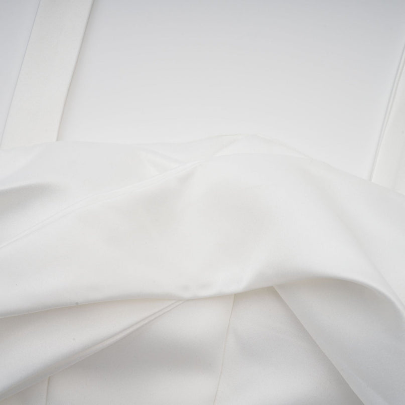 A white halterneck mini dress with ruffled details named Olivia worn by a model against a plain background