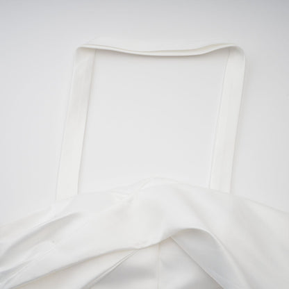 A white halterneck mini dress with ruffled details worn by a model named Olivia featuring a sleeveless design and a short hemline