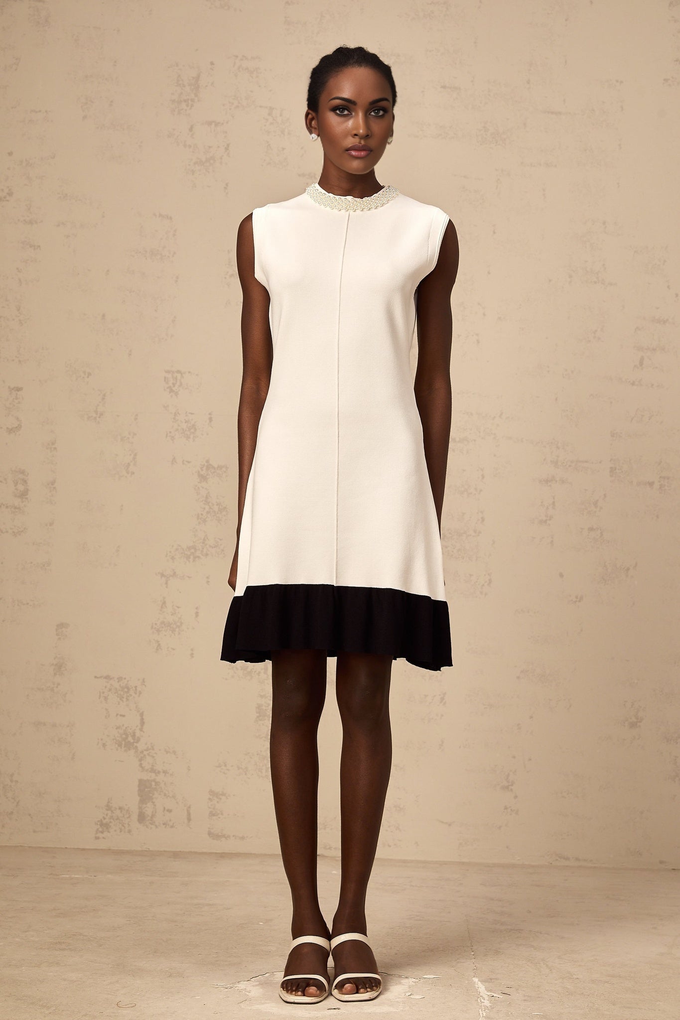 A white knitted cardigan adorned with faux pearl embellishments named Coralie