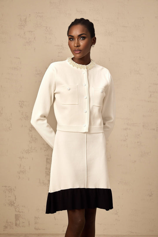 A white knitted cardigan adorned with faux pearl embellishments