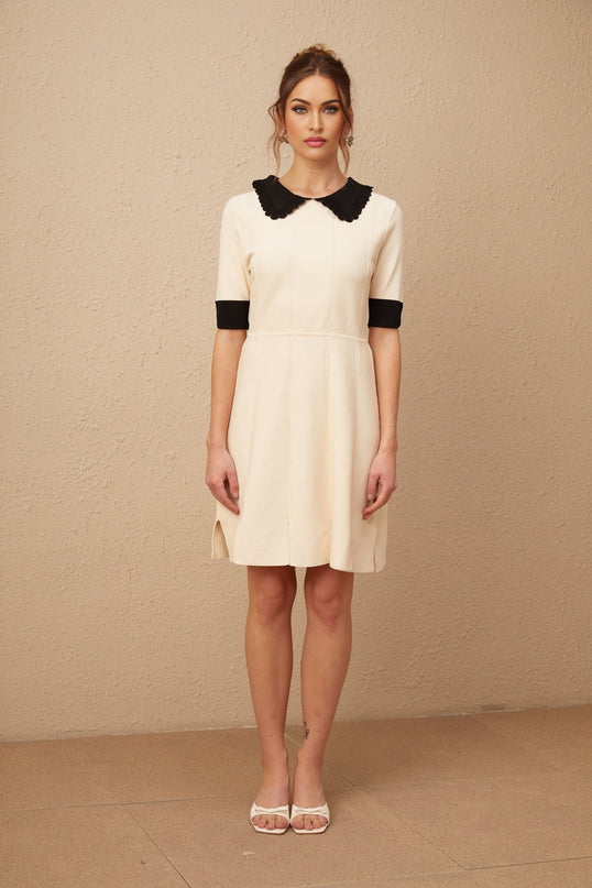 A white knitted mini dress with a split hem design worn by a model named Andrea