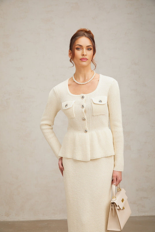 A white knitted twopiece outfit featuring a sleeveless top and matching skirt set called Manon