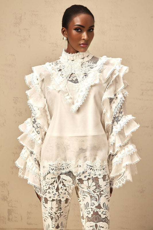 A white lace blouse with layered details and tie closure named Mylène