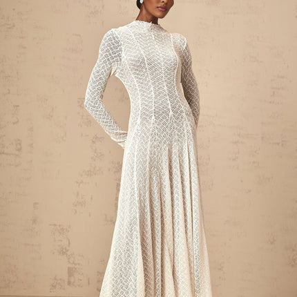 A white lace maxi dress with a wavy pattern design and long flowing silhouette