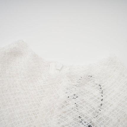 A white lace maxi dress with a wavy pattern featuring long sleeves and a floor length skirt