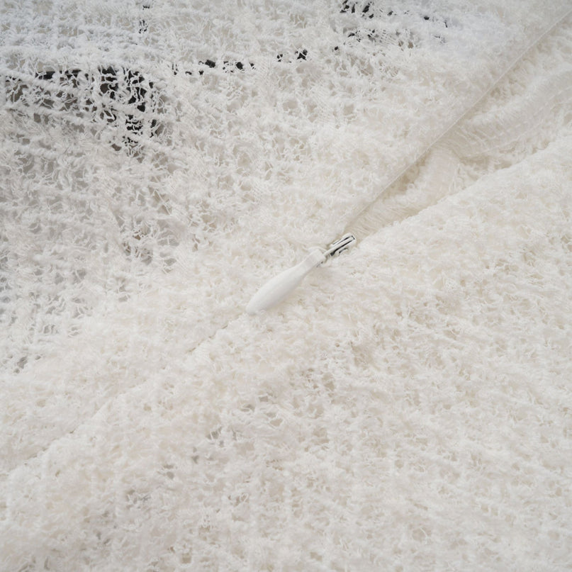 A white lace maxi dress with a wavy pattern featuring long sleeves and a flowy silhouette