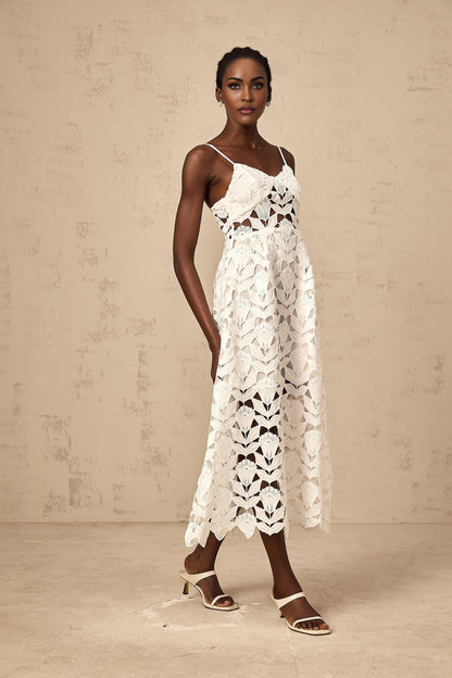 A white lace midi dress with cut out details featuring a delicate floral pattern and a fitted silhouette