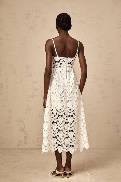 A white lace midi dress with cutout details featuring a delicate floral pattern and a fitted silhouette