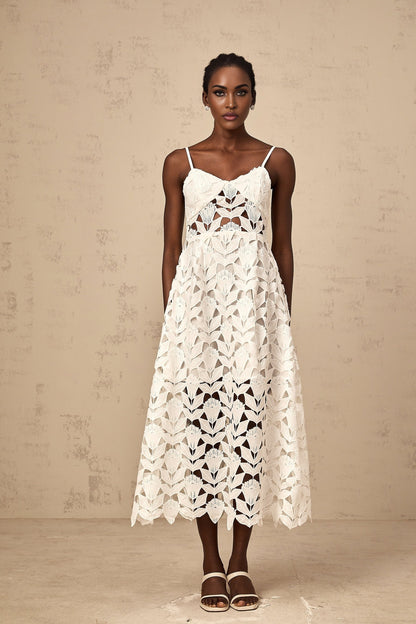 A white lace midi dress with cutout details featuring a delicate floral pattern and fitted silhouette