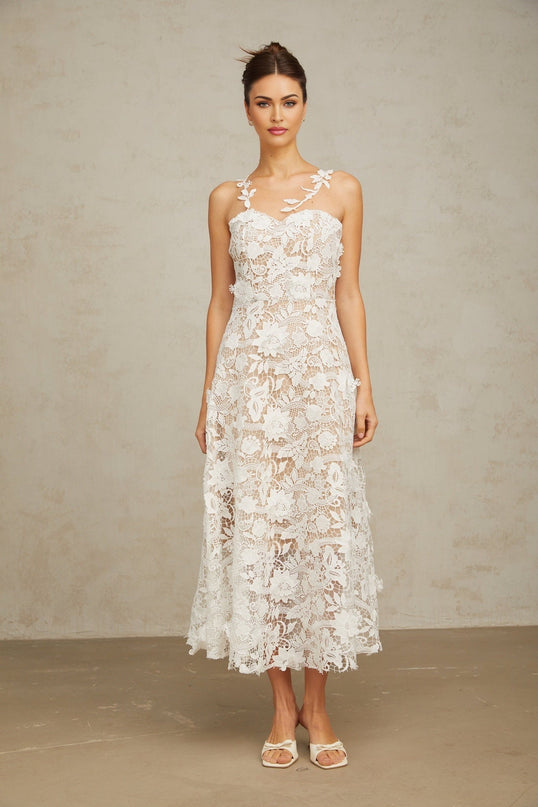 A white lace midi dress with tulle panels named Carole featuring a delicate feminine design with a blend of lace and sheer tulle fabric reaching to mid calf length