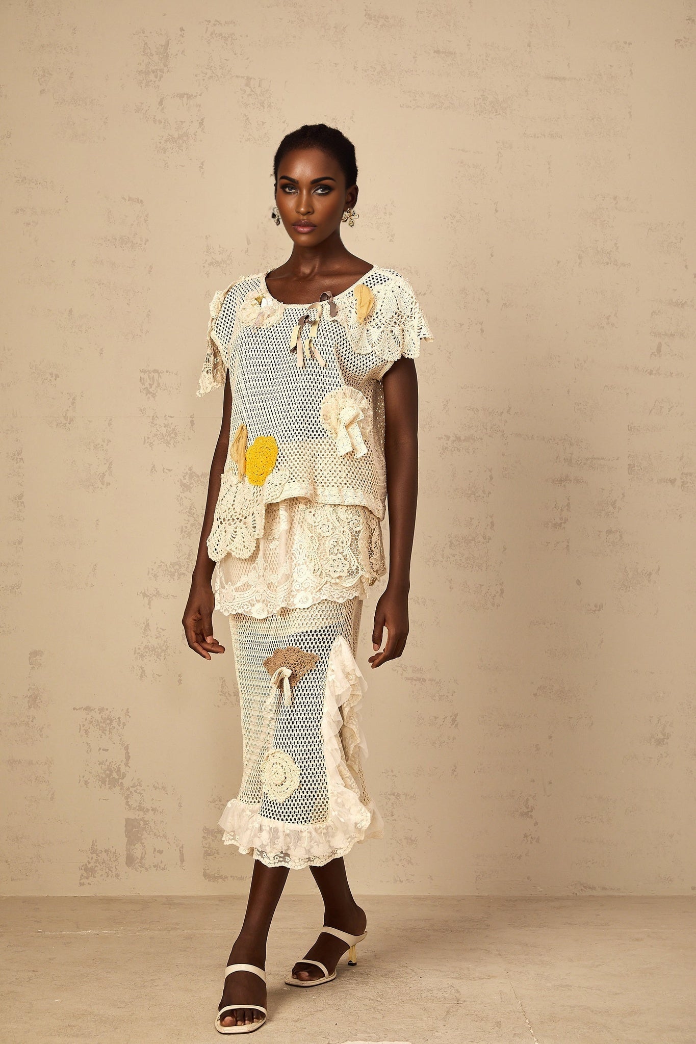 A white lacepaneled midi skirt with crochet knit detailing hanging on display