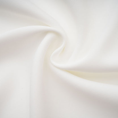 A white matching set featuring a creased top and trousers worn by a model against a plain background