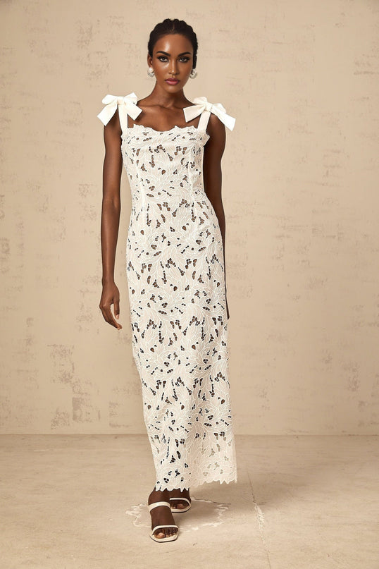 A white maxi dress with delicate floral embroidery named Eloise featuring a long flowing design and intricate stitched floral patterns throughout the fabric