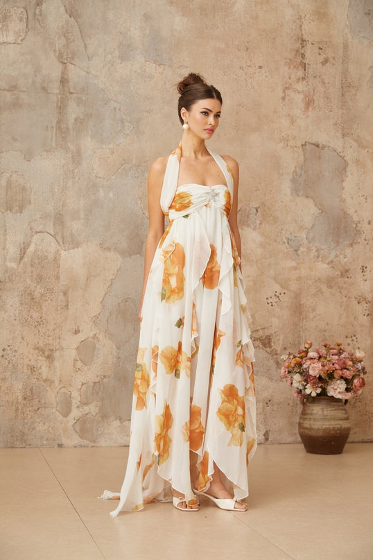 A white maxi dress with floral print and ruffled tulle details featuring a flowing design and feminine silhouette