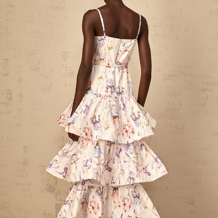A white maxi dress with floral print featuring ruffles and tiered design worn by a woman