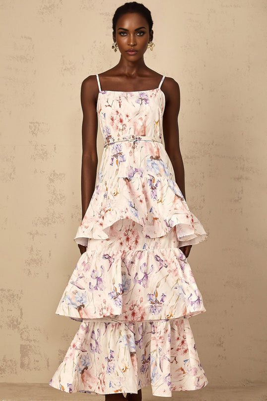 A white maxi dress with floral print featuring ruffles and tiered layers worn by a woman