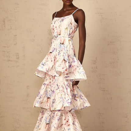 A white maxi dress with floral print featuring ruffles and tiered layers worn by a woman