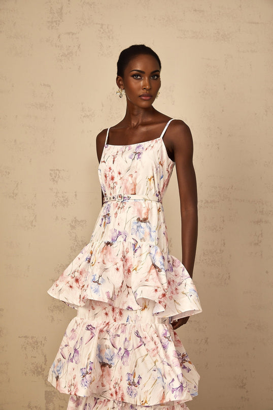 A white maxi dress with floral print pattern featuring ruffled tiers and a long flowing skirt