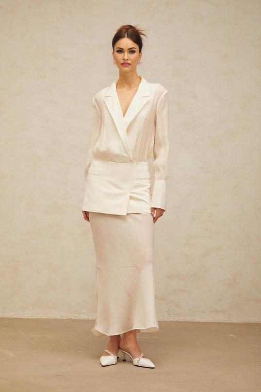 A white maxi dress with semisheer panelling named Gisele worn by a model standing against a plain background