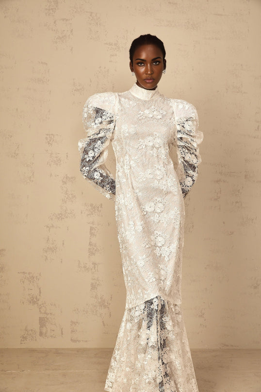 A white mermaid style maxi dress with floral lace detailing named Pauline featuring a fitted bodice and flared skirt