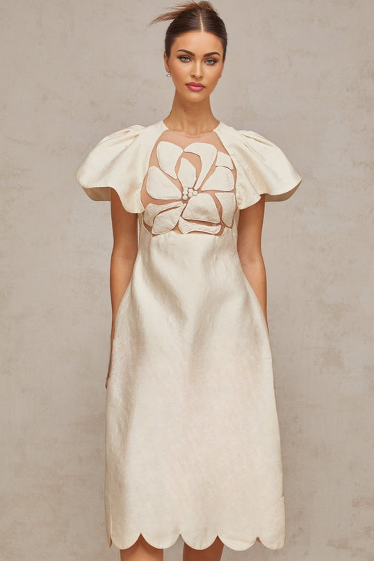 A white midi dress with a floral jacquard pattern featuring a feminine silhouette and delicate flower designs throughout the fabric