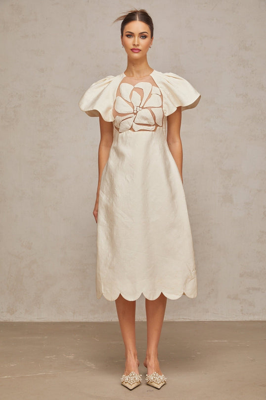 A white midi dress with a floral jacquard pattern featuring a fitted bodice and flared skirt
