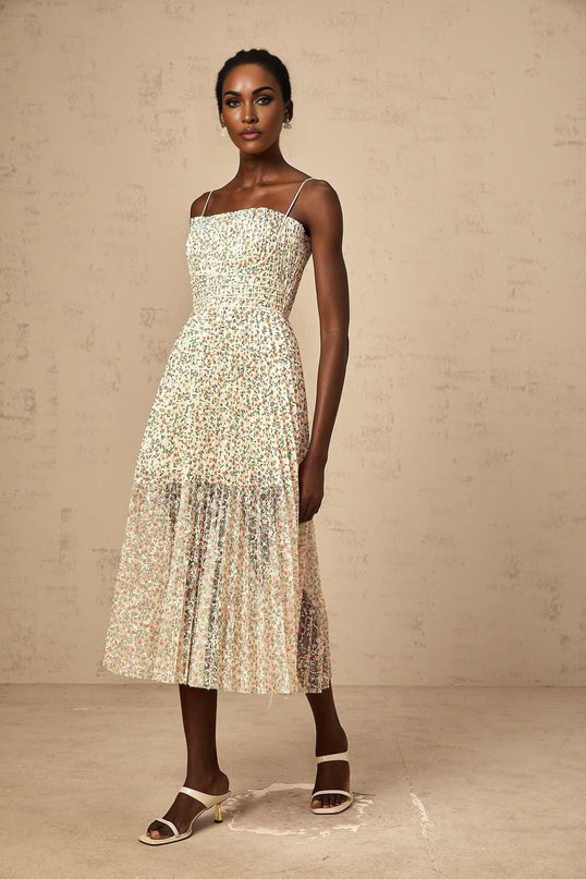 A white midi dress with a floral print pattern and pleated design featuring a feminine silhouette and delicate details